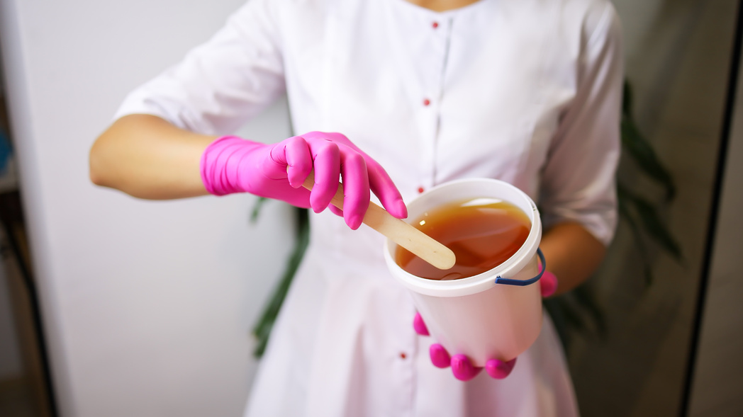A Sugar Epilation Master Picks up the Epilation Paste with a Spa