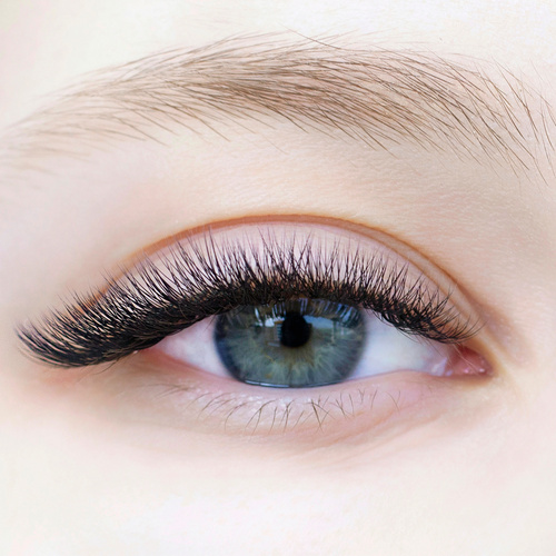 Eyelash extensions. Close-up of eyes with extended eyelashes of a white girl